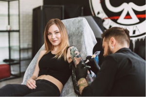 Woman getting tattooed on her left arm