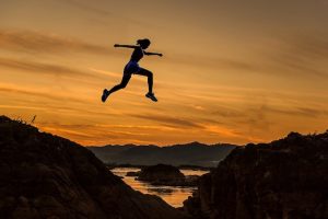 Woman jumping between hills