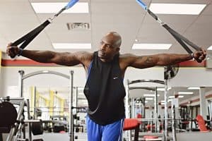 man holding arm straps at gym