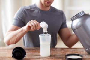 man making protein drink with powder