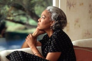 pensive older woman looking out window